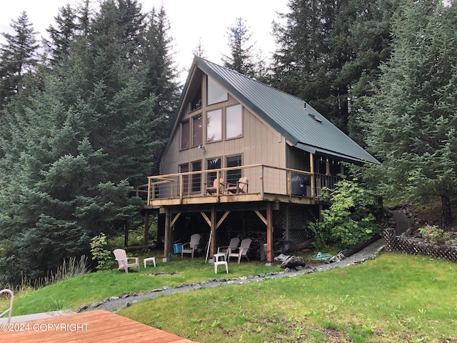 rear view of property with a lawn and a wooden deck