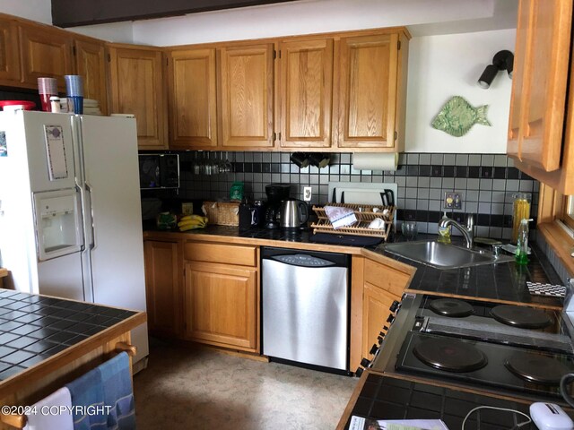 kitchen with dishwasher, tasteful backsplash, white fridge with ice dispenser, and tile counters