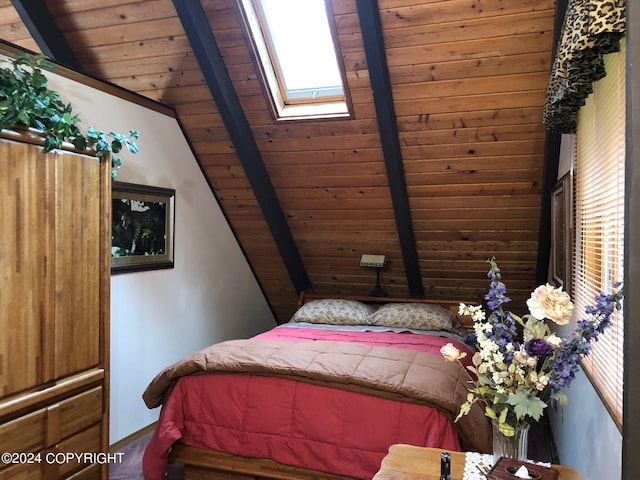 bedroom with vaulted ceiling with skylight, multiple windows, and wooden ceiling