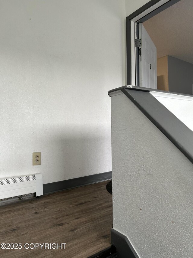 3940 E 9th Ave, Anchorage, AK 99508 - room details featuring radiator heating unit, wood finished floors, and baseboards