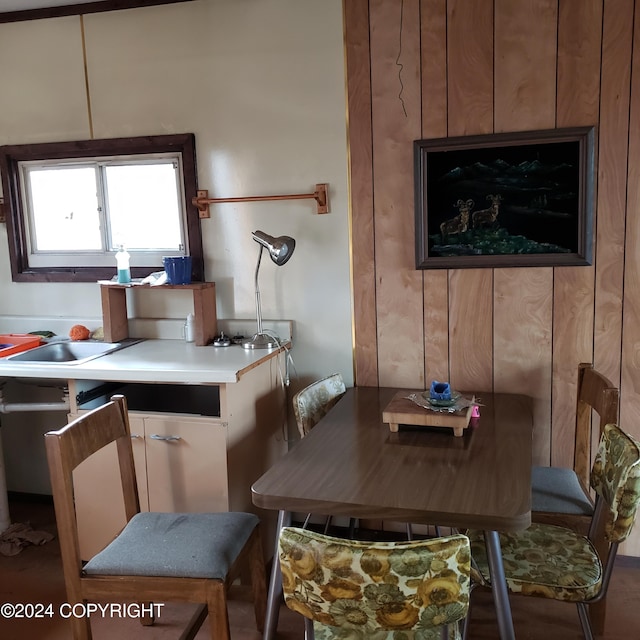 dining space featuring wood walls