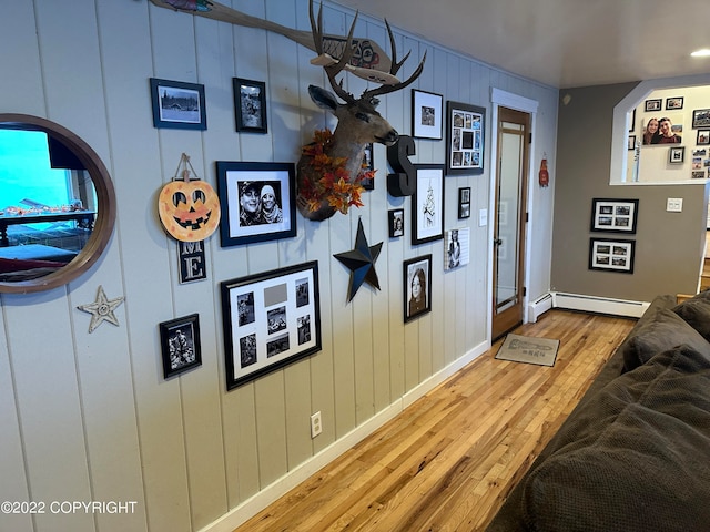 living room with a baseboard radiator and light hardwood / wood-style flooring