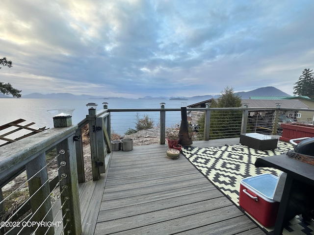 wooden terrace featuring a water and mountain view