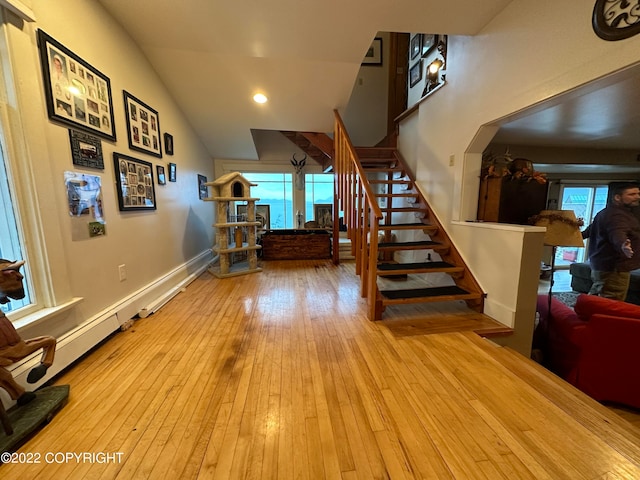 staircase featuring light hardwood / wood-style floors and vaulted ceiling