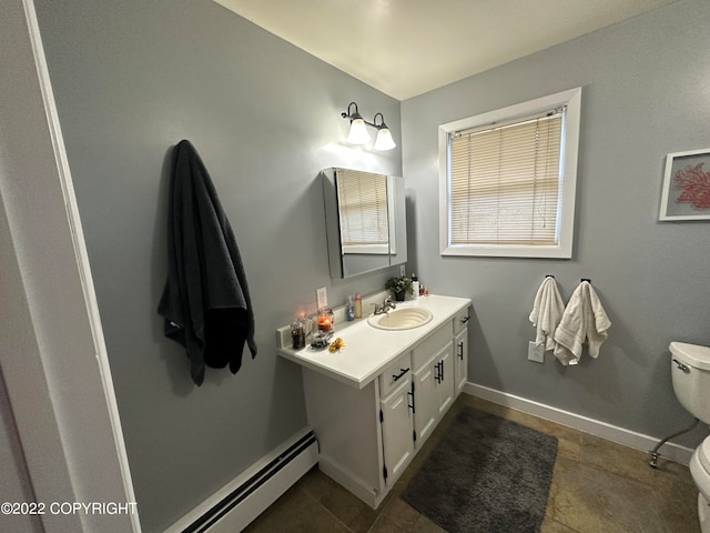 bathroom with toilet, large vanity, a baseboard heating unit, and tile flooring