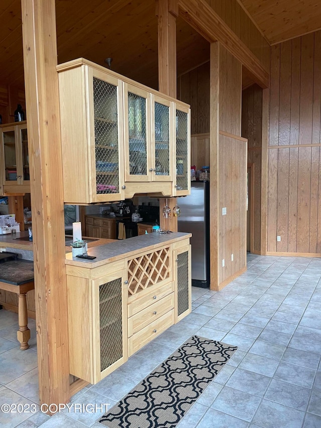 kitchen featuring wooden ceiling, light tile flooring, and wood walls