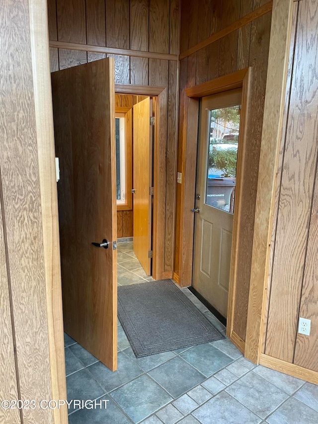 hall with light tile floors and wood walls