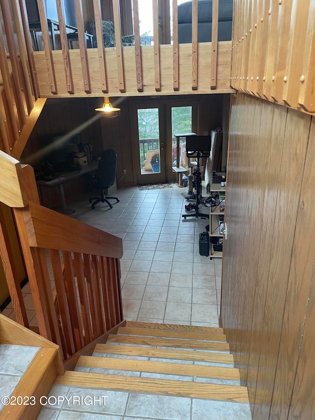 stairway with light tile floors and wood walls