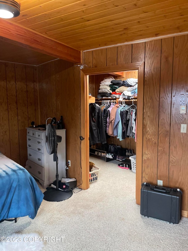 bedroom with carpet, wooden walls, a closet, and wood ceiling