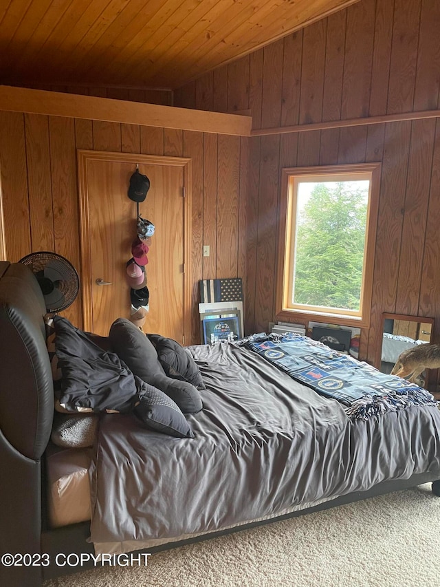 bedroom featuring carpet flooring, wooden walls, and wooden ceiling