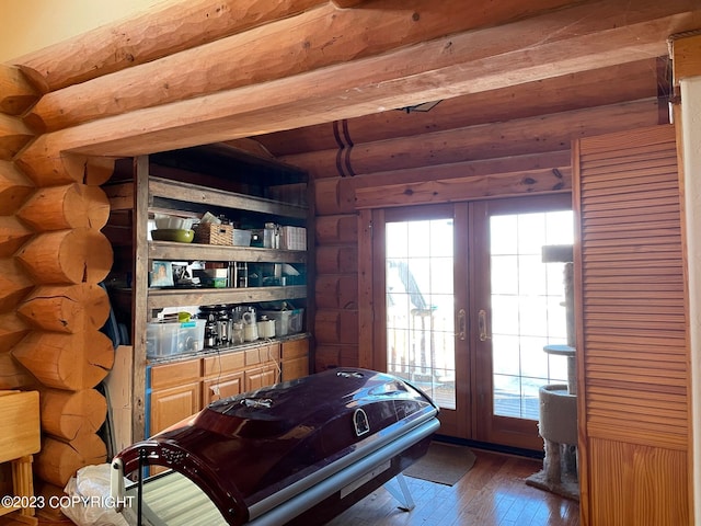 bedroom with log walls, dark wood-type flooring, and french doors