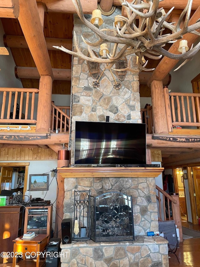 living room with an inviting chandelier, a high ceiling, hardwood / wood-style flooring, and a fireplace