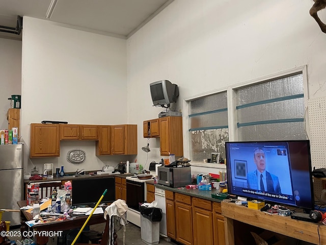 kitchen featuring stainless steel fridge, white range with electric stovetop, sink, and dishwashing machine