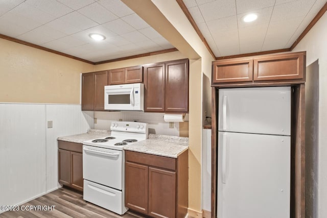 kitchen with white appliances, ornamental molding, and dark hardwood / wood-style floors