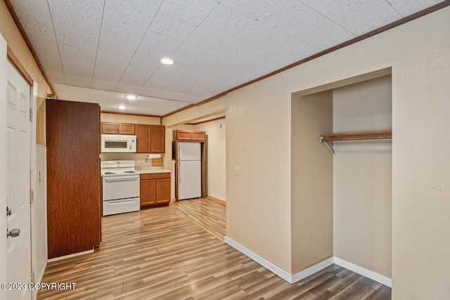 kitchen featuring crown molding, white appliances, and light hardwood / wood-style floors