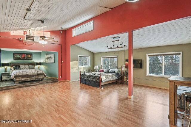 bedroom featuring multiple windows, light hardwood / wood-style floors, ceiling fan, and a towering ceiling