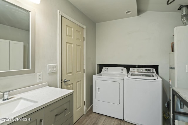 washroom featuring light hardwood / wood-style flooring, sink, and washer and dryer