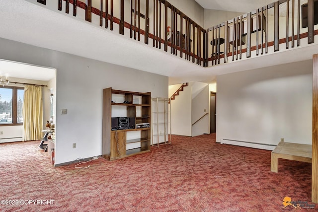 unfurnished living room featuring stairway, baseboard heating, carpet, and a towering ceiling