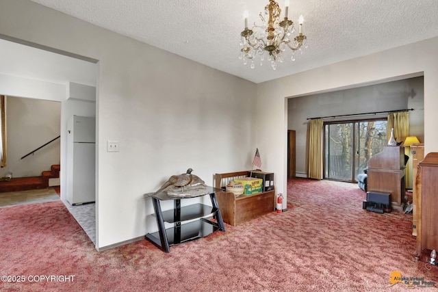 playroom featuring carpet floors, a textured ceiling, baseboards, and an inviting chandelier