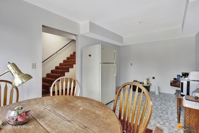 dining area featuring carpet floors and stairway