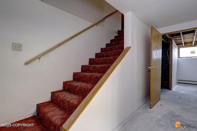 stairs featuring concrete flooring and a baseboard radiator