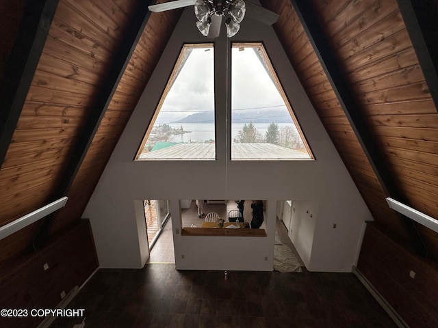 bonus room featuring wood ceiling, dark tile floors, high vaulted ceiling, and ceiling fan