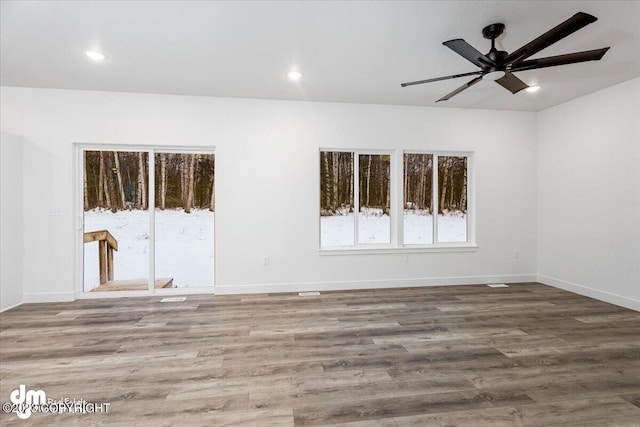 spare room with recessed lighting, baseboards, and wood finished floors