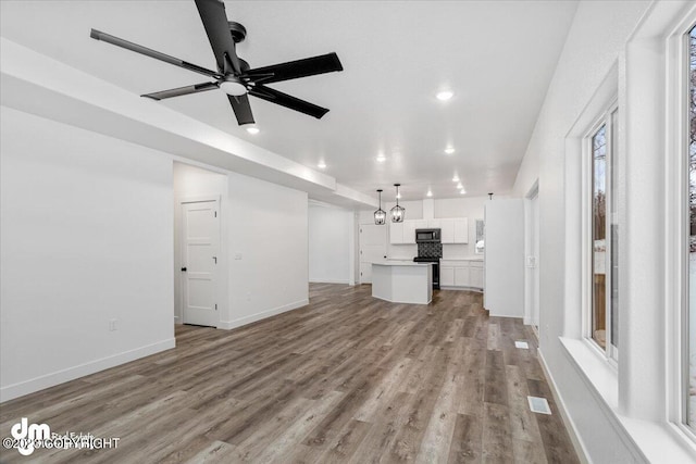 unfurnished living room featuring recessed lighting, a ceiling fan, baseboards, and wood finished floors