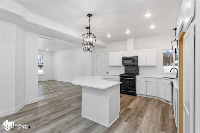 kitchen featuring light hardwood / wood-style floors, tasteful backsplash, range with electric cooktop, a kitchen island, and white cabinets