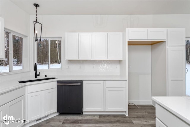 kitchen with a sink, wood finished floors, dishwasher, and white cabinets