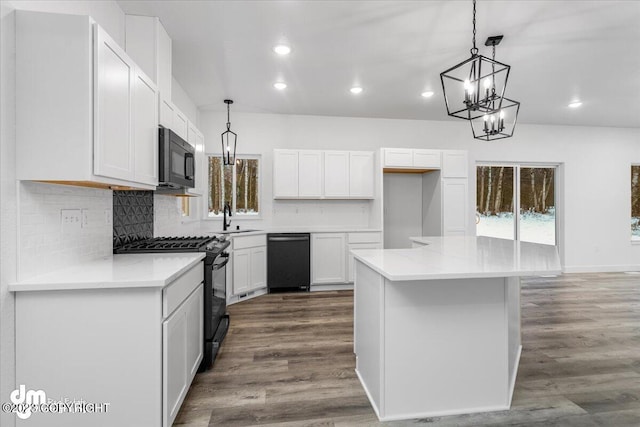 kitchen with tasteful backsplash, black appliances, dark wood finished floors, and white cabinetry