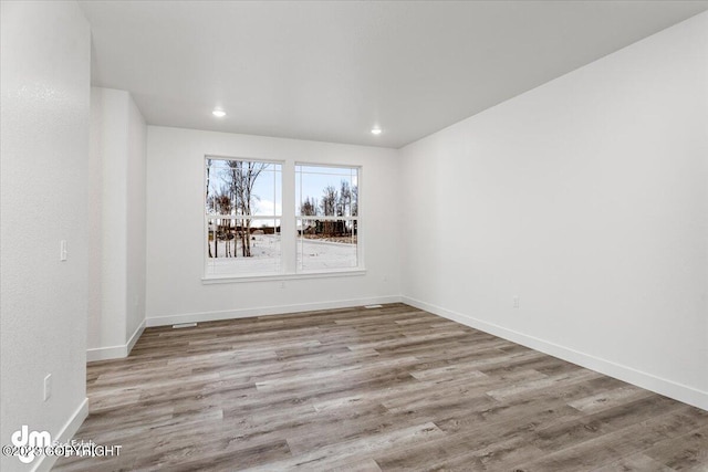 unfurnished room with recessed lighting, baseboards, and wood finished floors