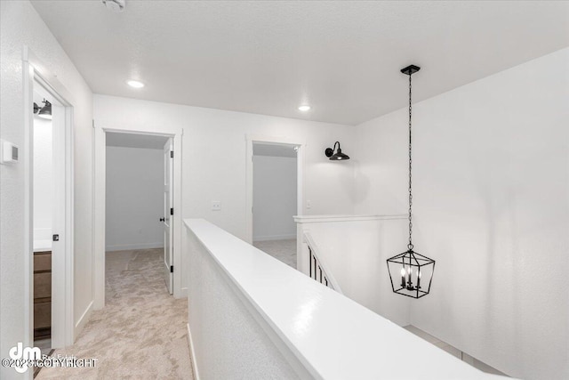 corridor featuring an upstairs landing, recessed lighting, light colored carpet, and baseboards