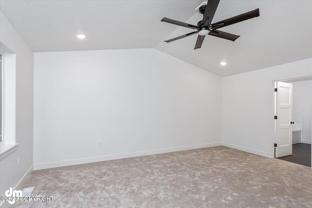 unfurnished room with vaulted ceiling, baseboards, carpet floors, and ceiling fan