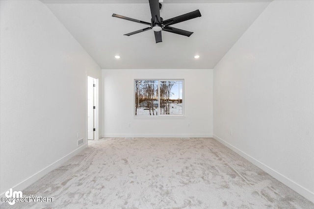 spare room with light carpet, ceiling fan, and vaulted ceiling