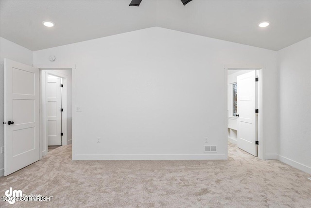 unfurnished bedroom featuring light carpet, lofted ceiling, and ceiling fan