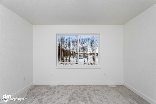 unfurnished room with carpet flooring, baseboards, and visible vents