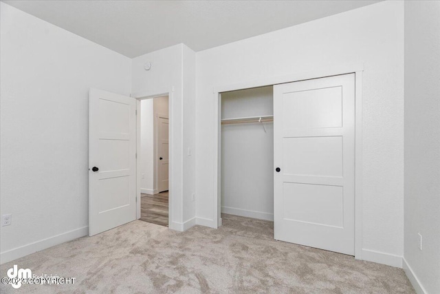 unfurnished bedroom featuring a closet and light carpet