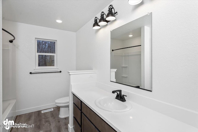 full bathroom with toilet, large vanity, wood-type flooring, bathing tub / shower combination, and a textured ceiling