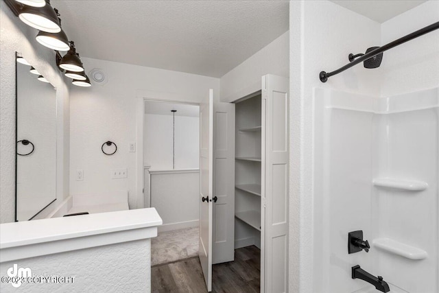 bathroom with shower / bath combination, a textured ceiling, wood finished floors, and vanity