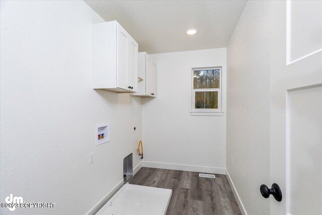 washroom with cabinets, hardwood / wood-style floors, hookup for a washing machine, a textured ceiling, and hookup for an electric dryer