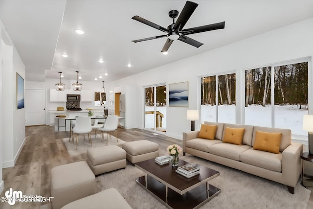 living room featuring ceiling fan and light hardwood / wood-style floors