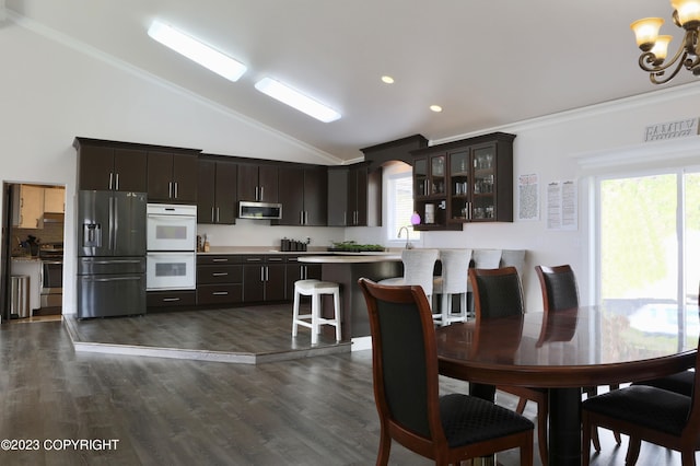 dining room featuring a chandelier, ornamental molding, high vaulted ceiling, and dark hardwood / wood-style flooring