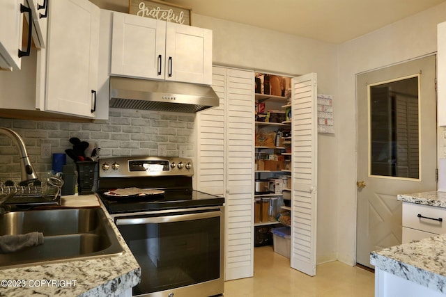 kitchen with white cabinetry, stainless steel electric range, light stone countertops, backsplash, and sink