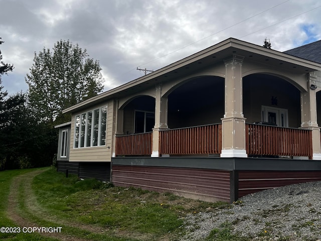 view of side of home featuring covered porch