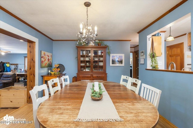 dining room with an inviting chandelier, light wood-style flooring, and ornamental molding