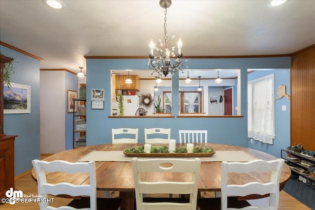 dining room featuring an inviting chandelier, crown molding, and wood finished floors