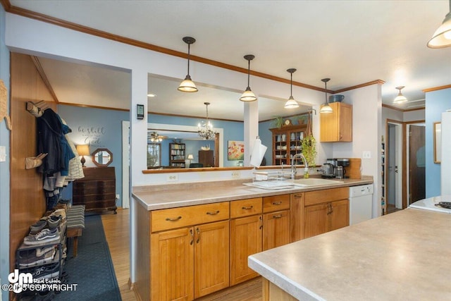 kitchen featuring light countertops, light wood-style floors, white dishwasher, hanging light fixtures, and a sink