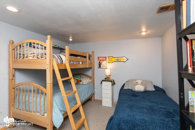 carpeted bedroom featuring visible vents and a textured ceiling