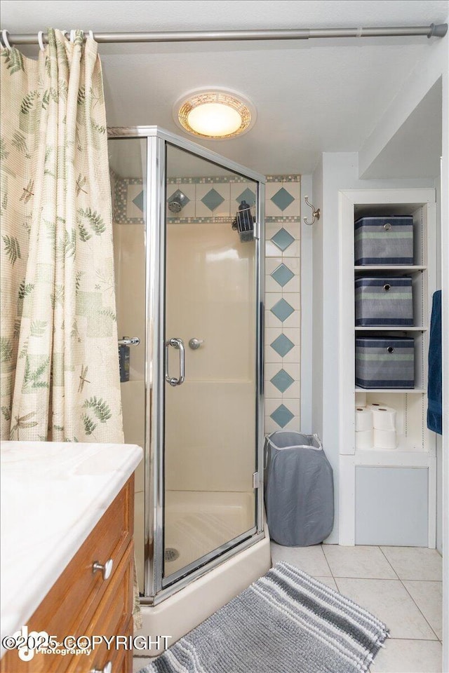 full bath featuring tile patterned floors, a stall shower, and vanity